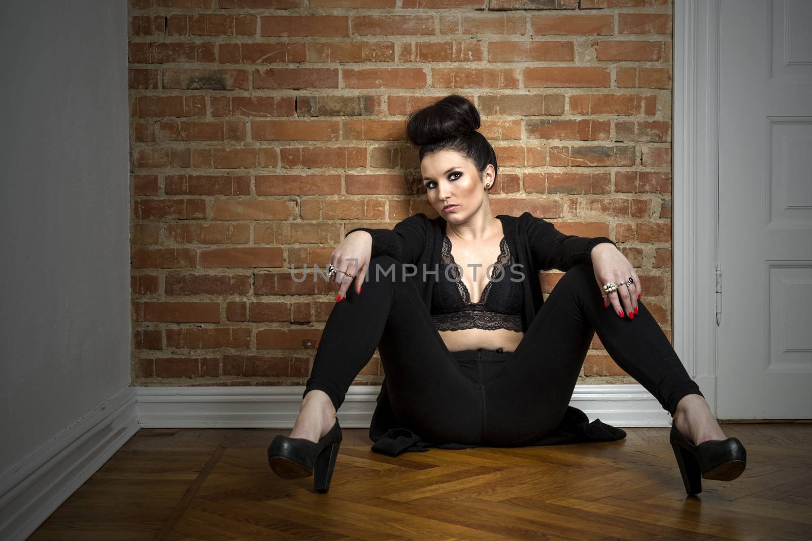 Moody elegant woman sitting on a parquet floor by MOELLERTHOMSEN