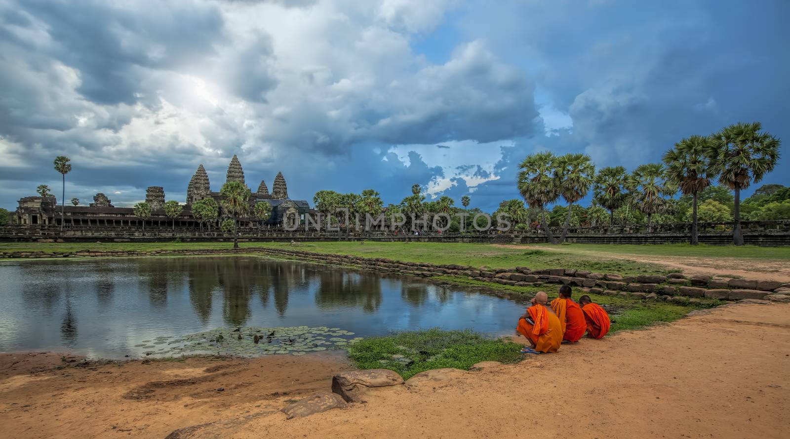 Monks watching the sunset over Angkor Wat from the lake