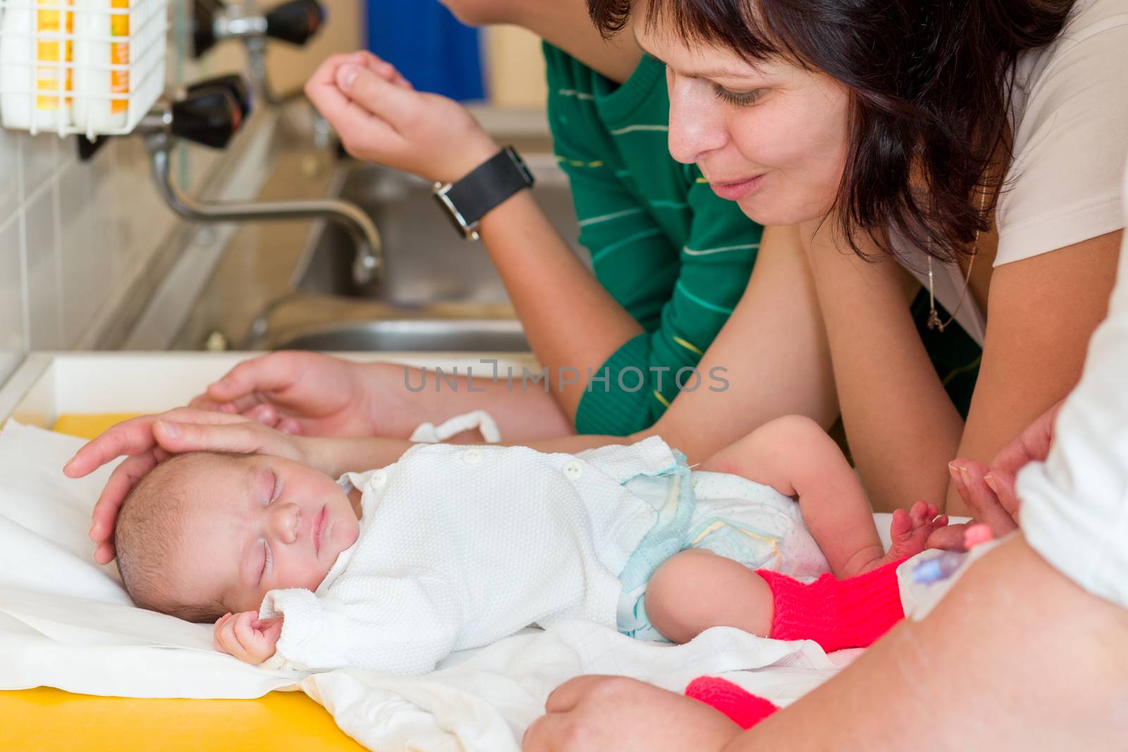 sleeping newborn baby in the hospital - the first hours of the new life, family looking to infant