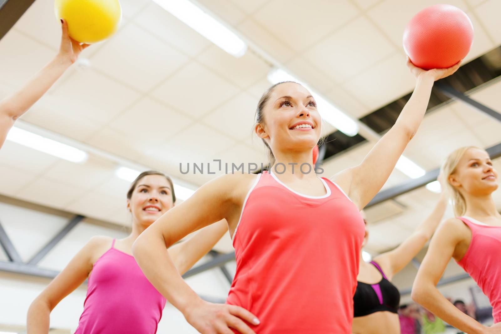 fitness, sport, training, gym and lifestyle concept - group of smiling people working out with stability balls in the gym