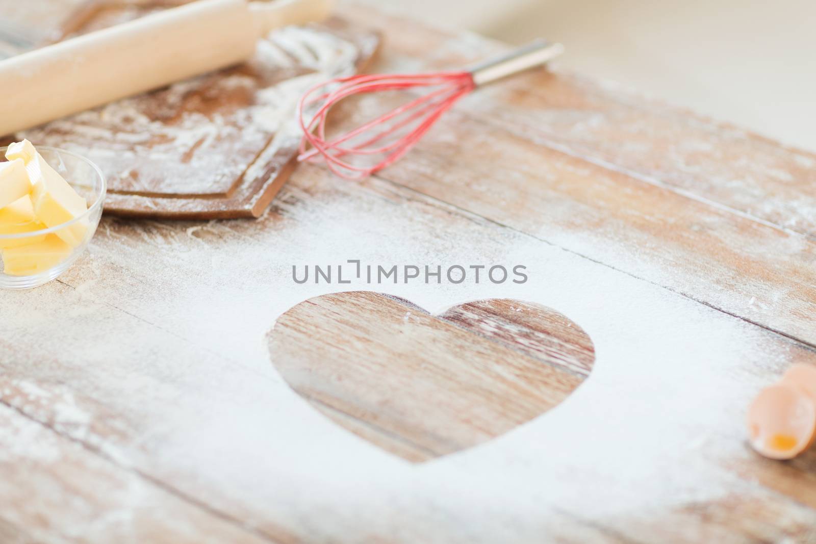 close up of heart of flour on wooden table at home by dolgachov