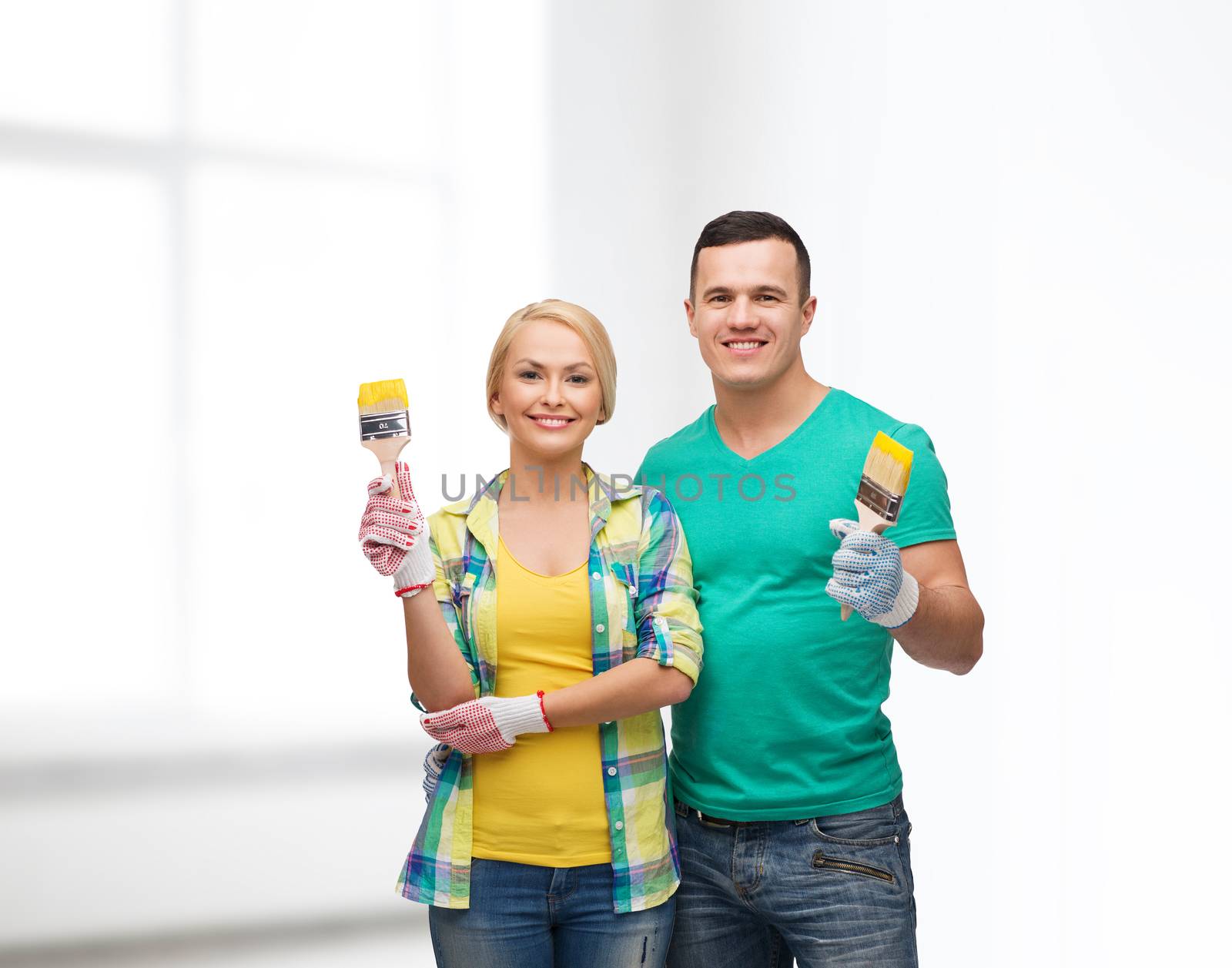 smiling couple with paintbrush by dolgachov