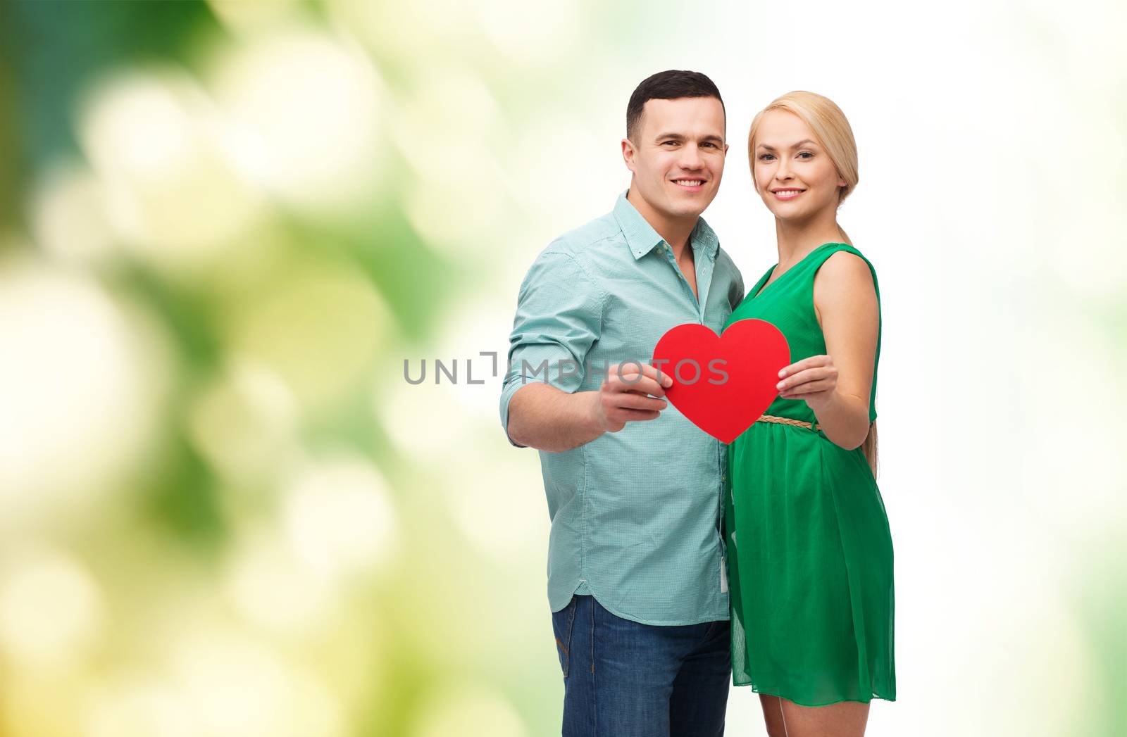 smiling couple holding big red heart by dolgachov