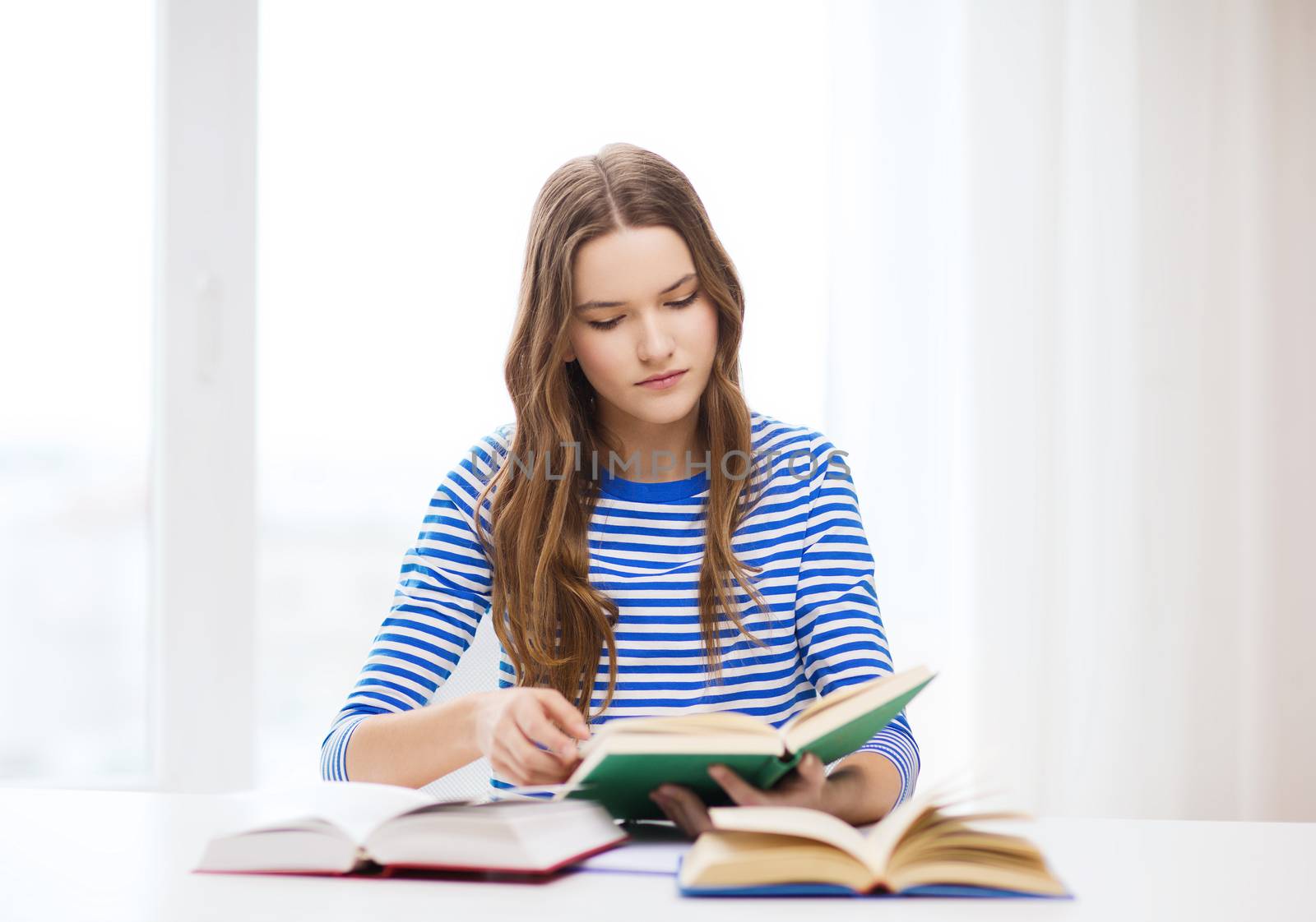 concentrated student girl with books by dolgachov