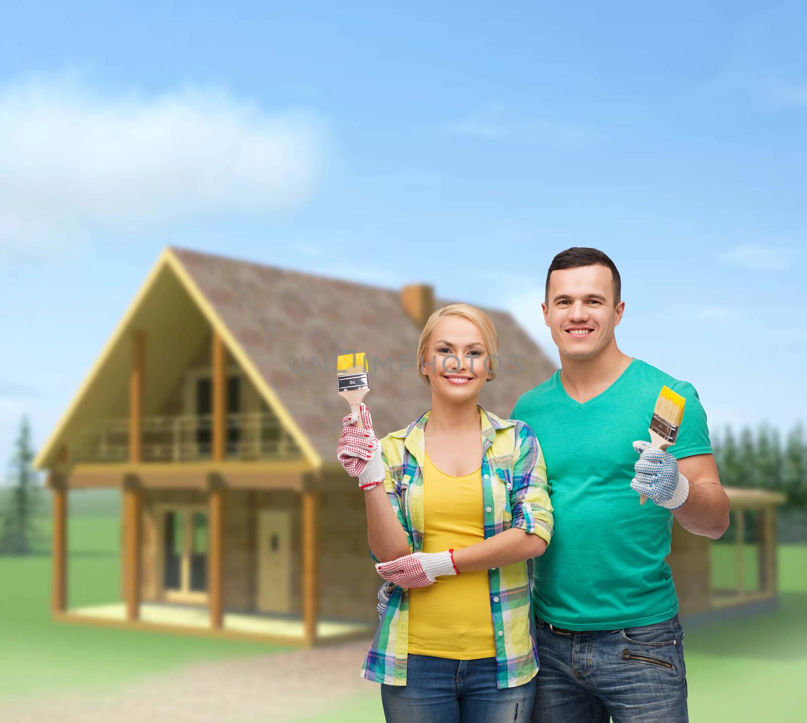 repair, construction and maintenance concept - smiling couple with paintbrush