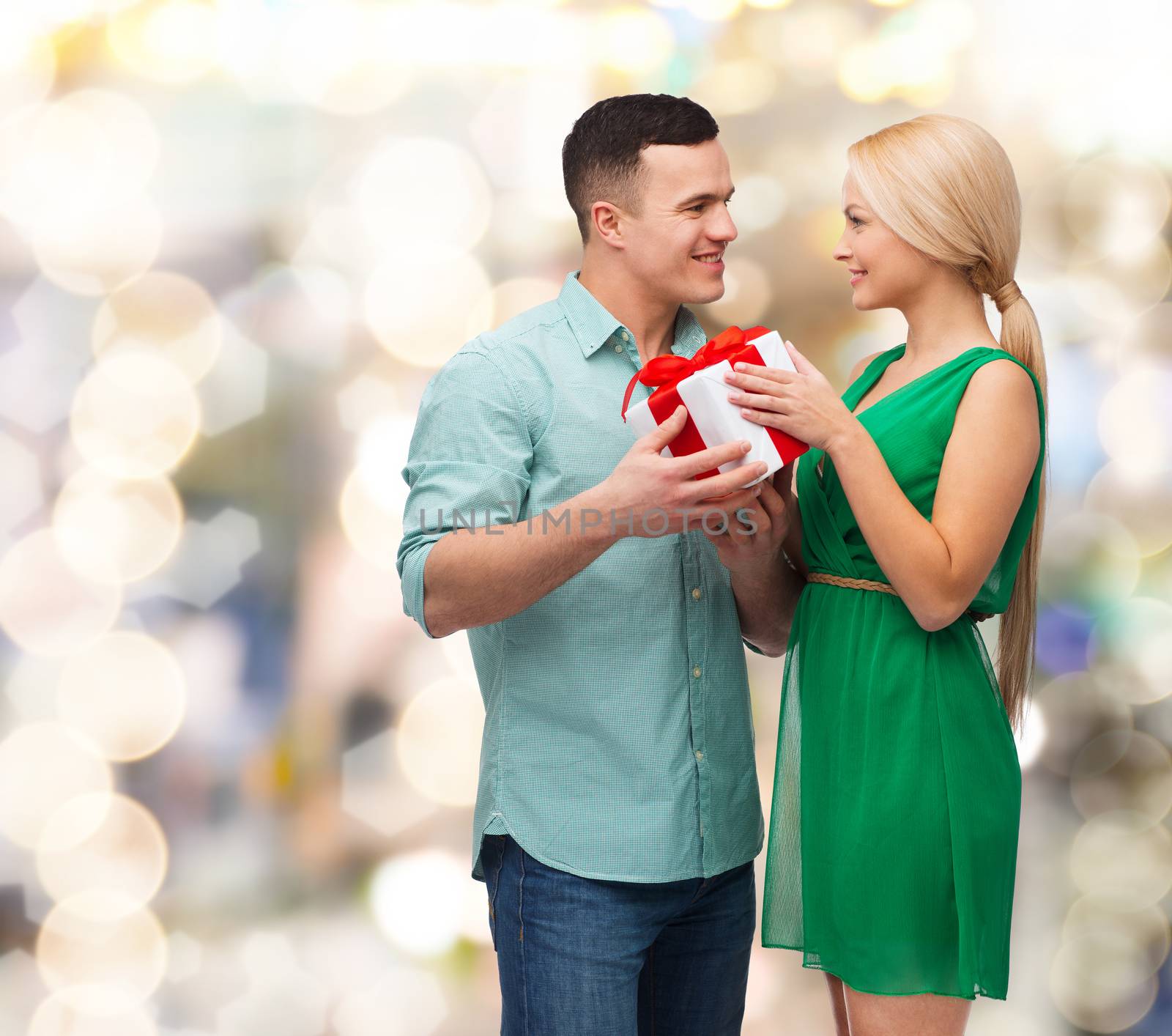 smiling couple with gift box by dolgachov