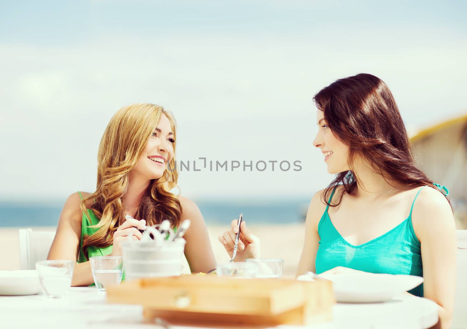 girls in cafe on the beach by dolgachov