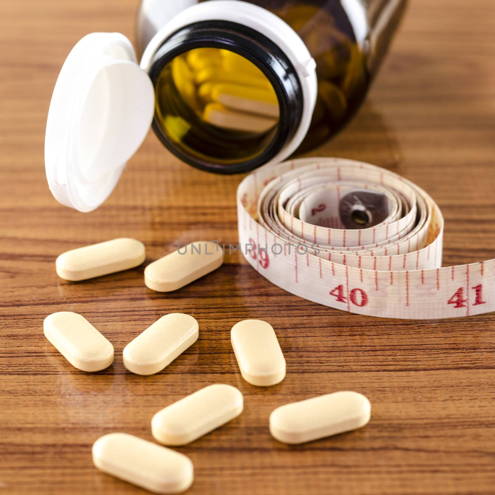 pills and measuring tape concept diet with drug