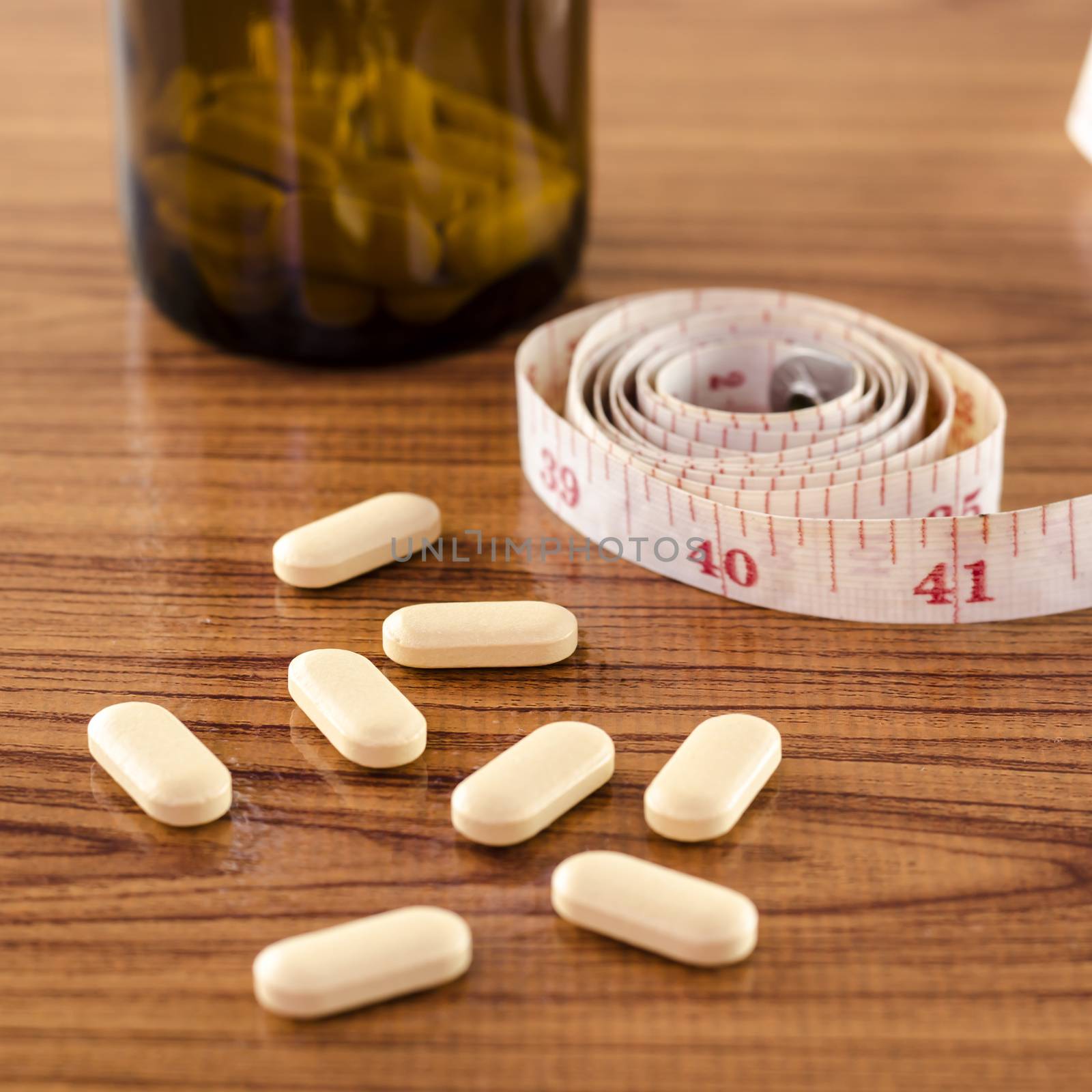 pills and measuring tape concept diet with drug