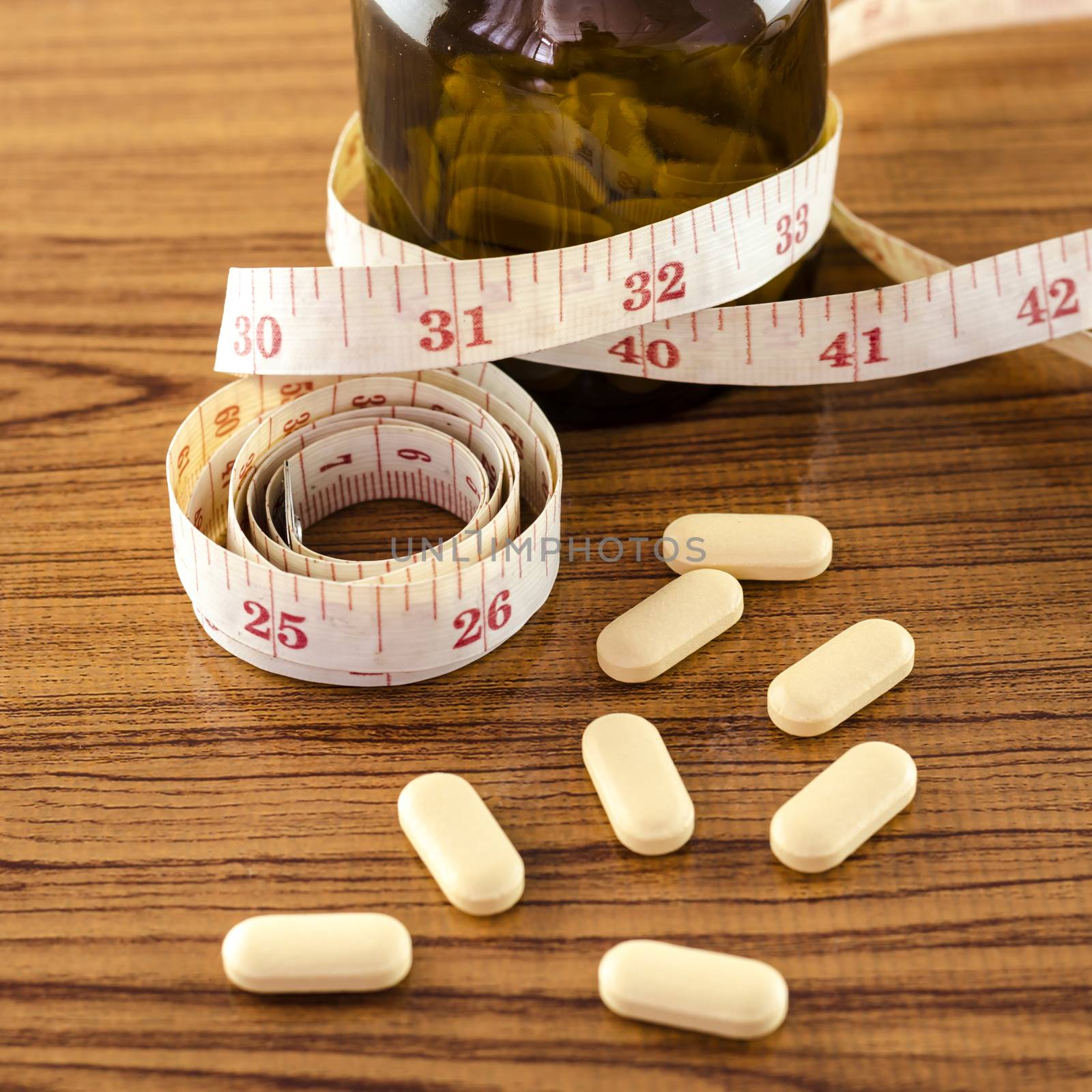 pills and measuring tape concept diet with drug