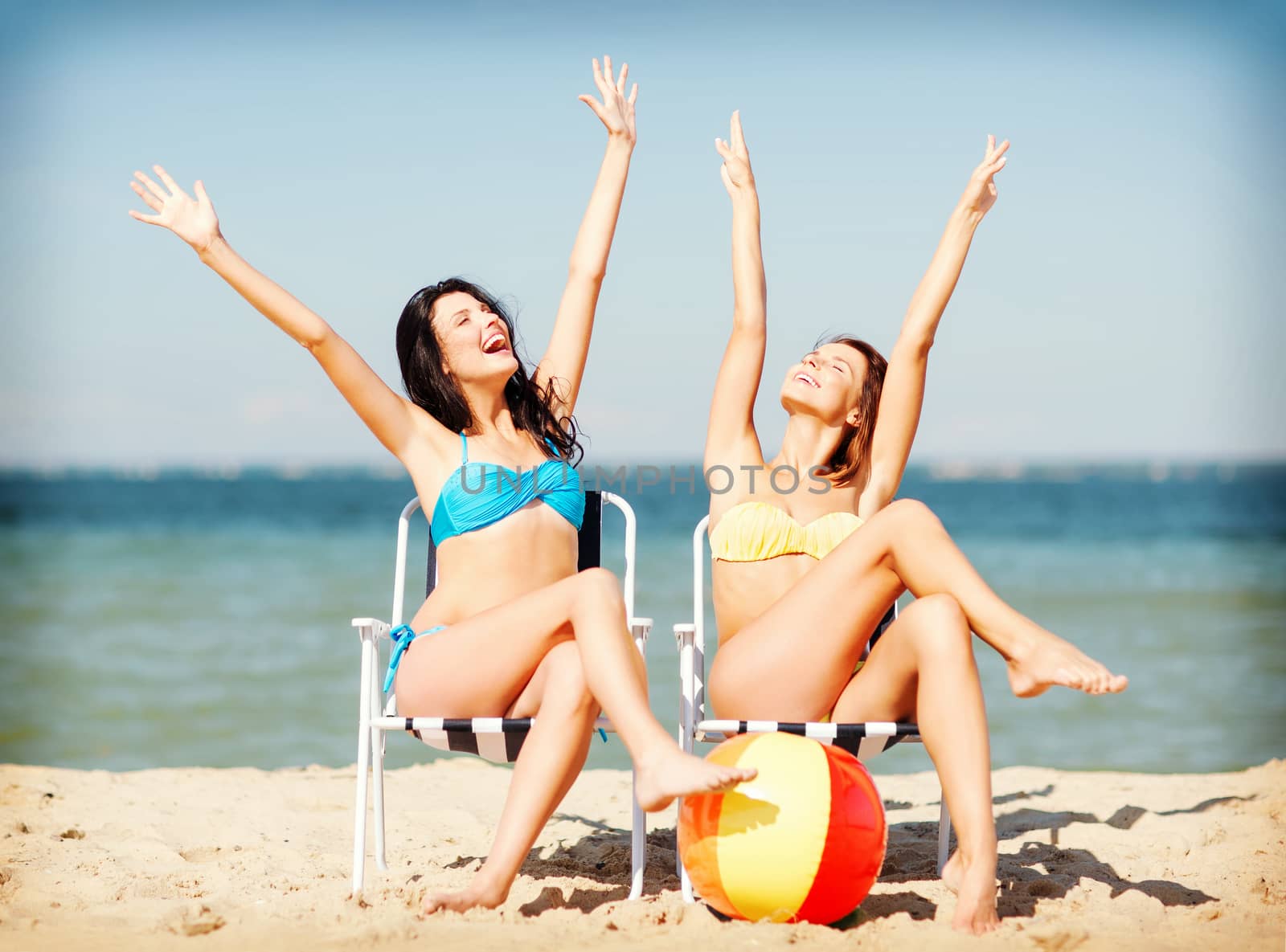 summer holidays and vacation - girls sunbathing on the beach chairs