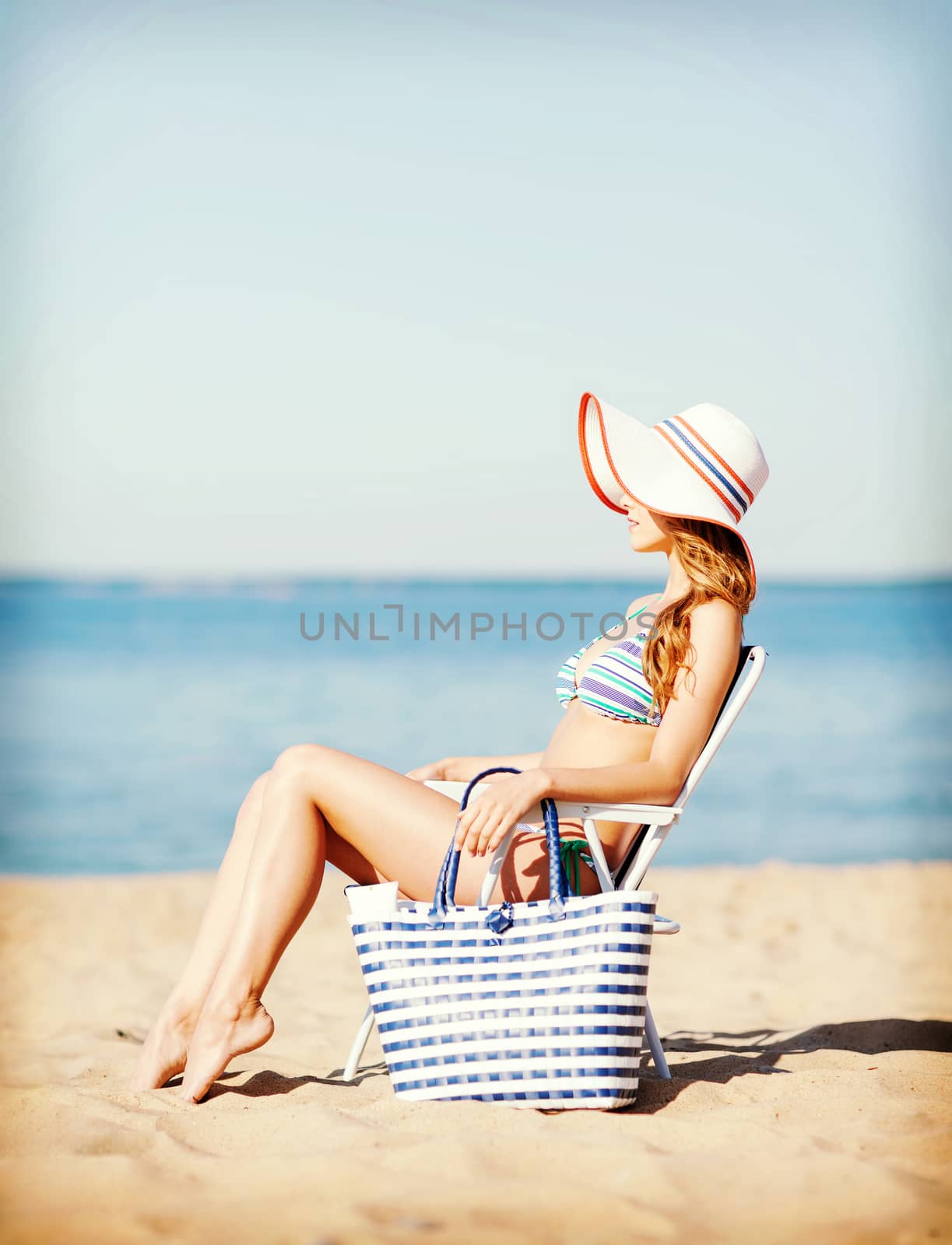 girl sunbathing on the beach chair by dolgachov