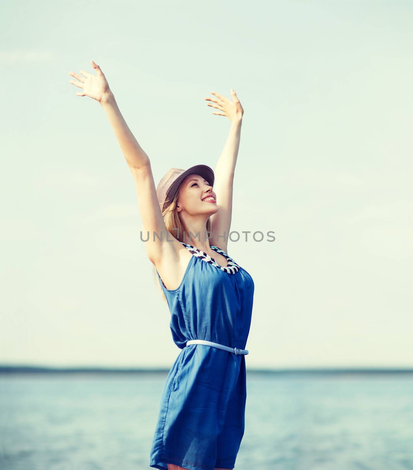 girl with hands up on the beach by dolgachov