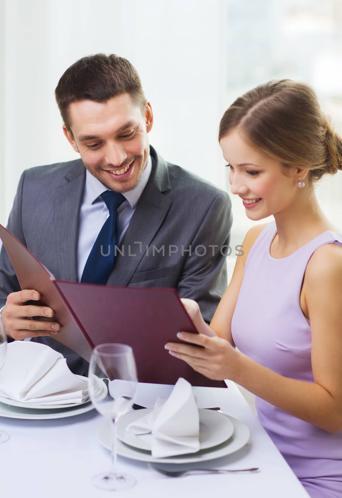 smiling couple with menu at restaurant by dolgachov
