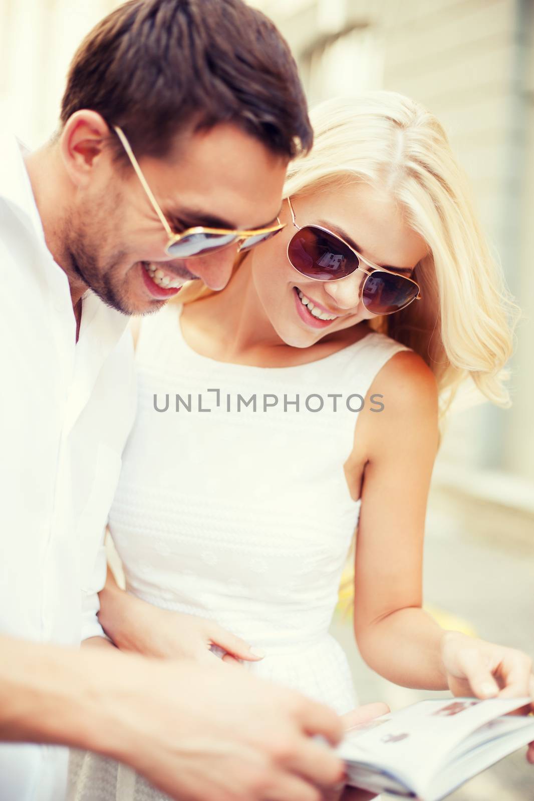 summer holidays, dating and tourism concept - couple with tourist book in the city