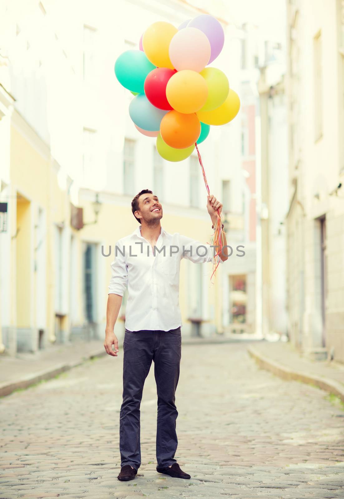 man with colorful balloons in the city by dolgachov