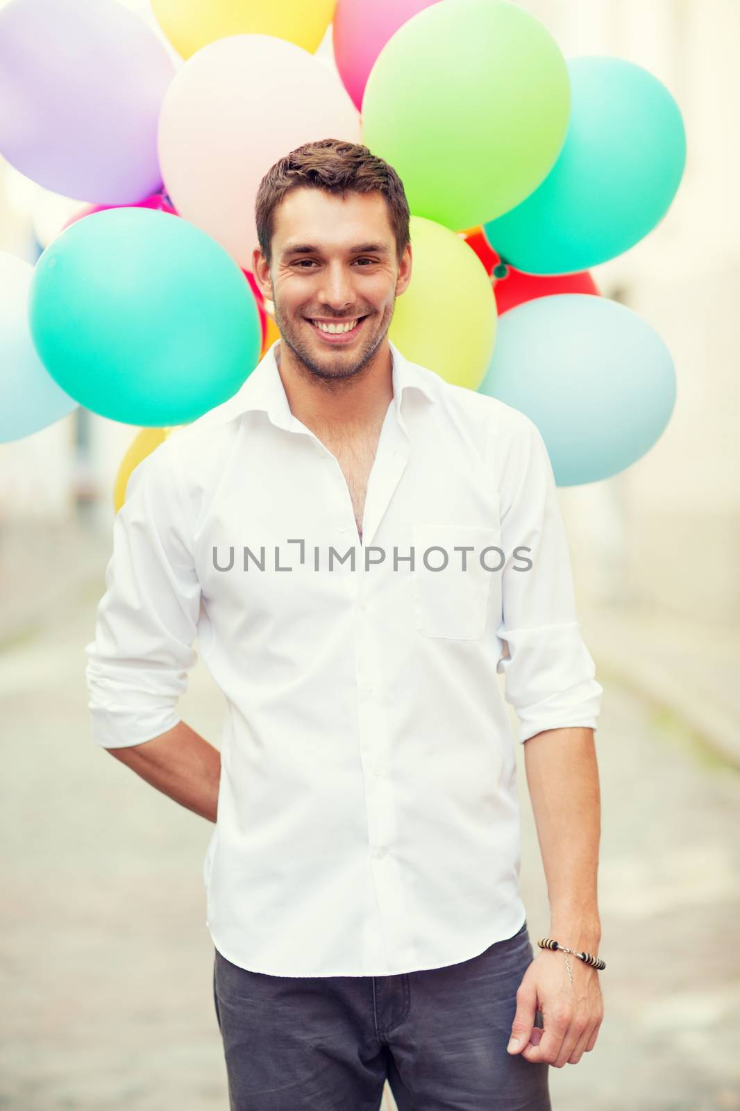 man with colorful balloons in the city by dolgachov