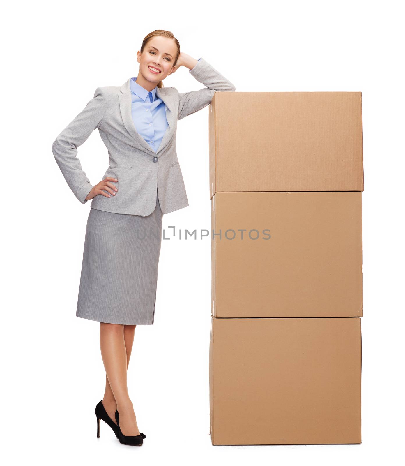 business, post and transportation concept - smiling businesswoman with tower of cardboard boxes