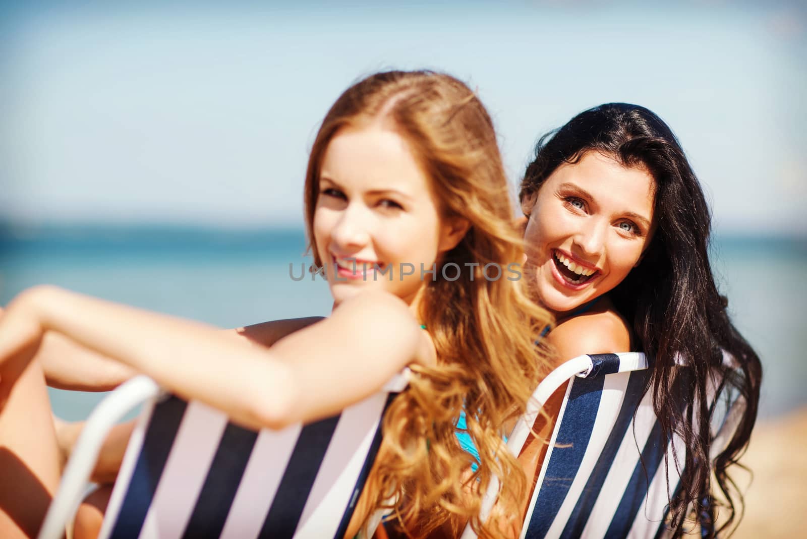 girls sunbathing on the beach chairs by dolgachov