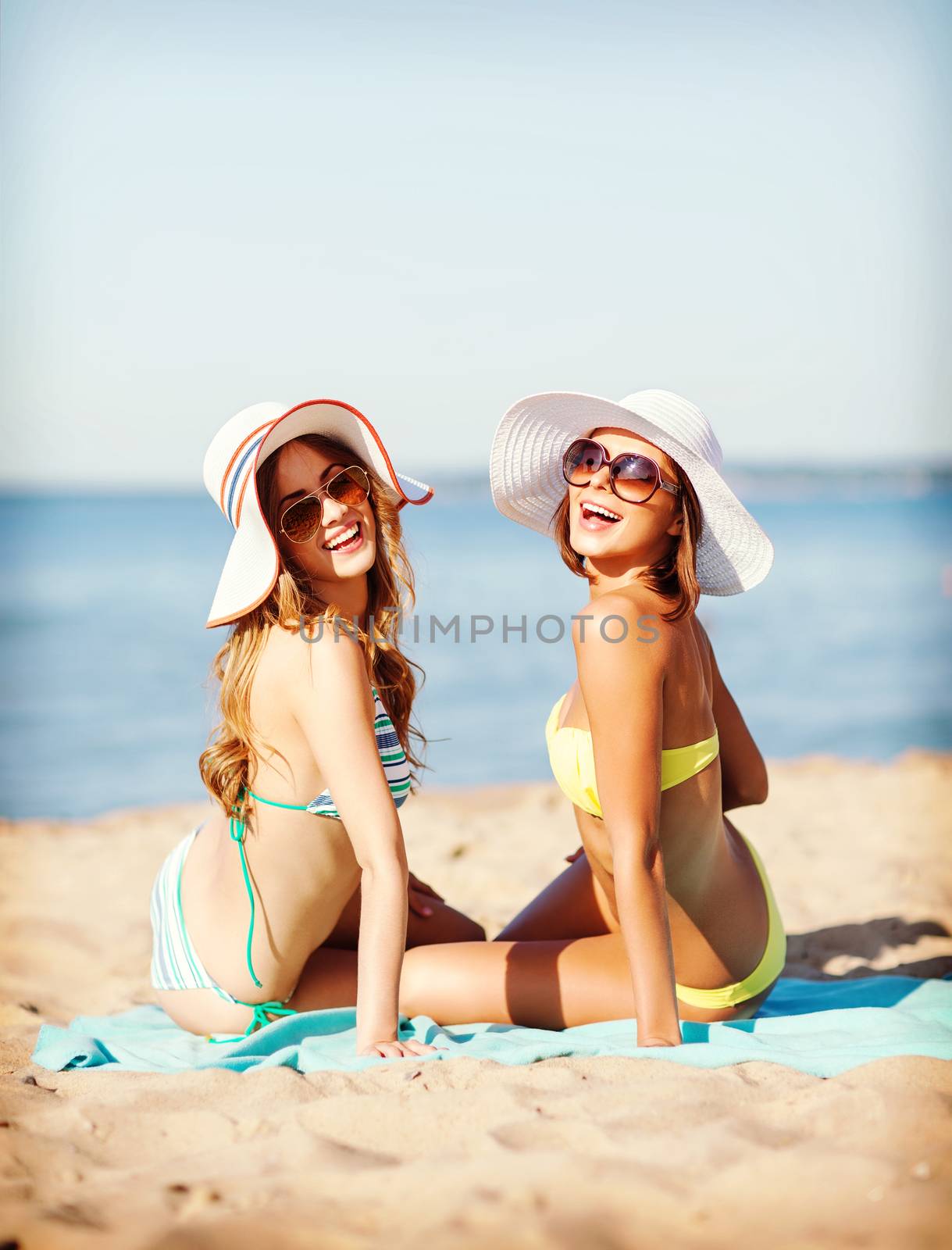girls sunbathing on the beach by dolgachov
