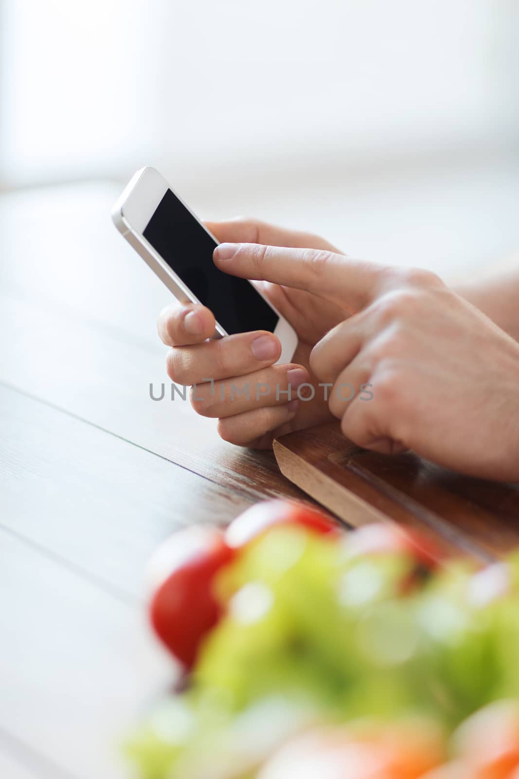 closeup of male hand pointing finger to smartphone by dolgachov