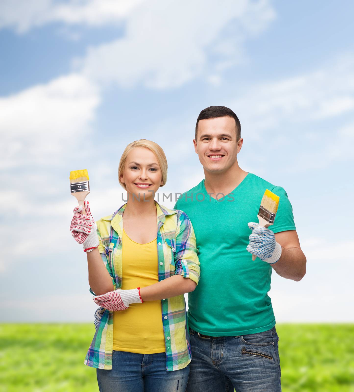 repair, construction and maintenance concept - smiling couple with paintbrush