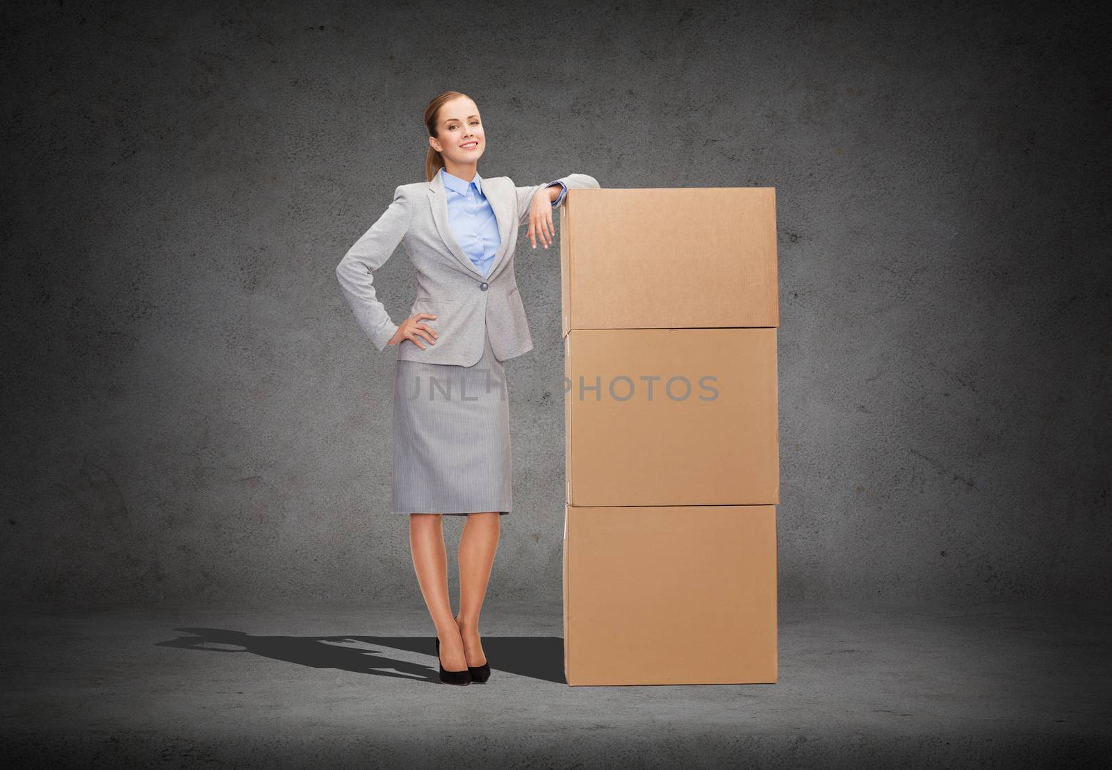 smiling businesswoman with cardboard boxes by dolgachov