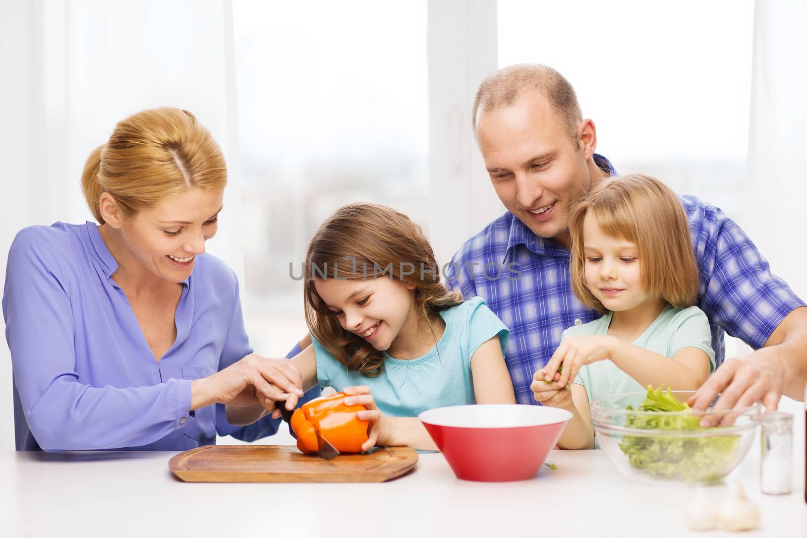 happy family with two kids making dinner at home by dolgachov