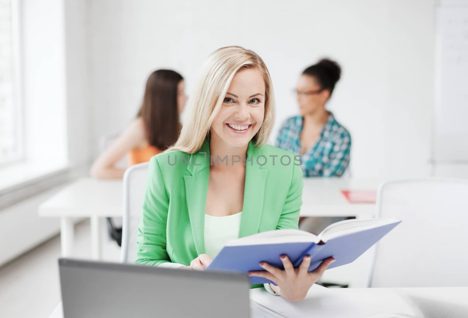 education concept - smiling young girl reading book at school