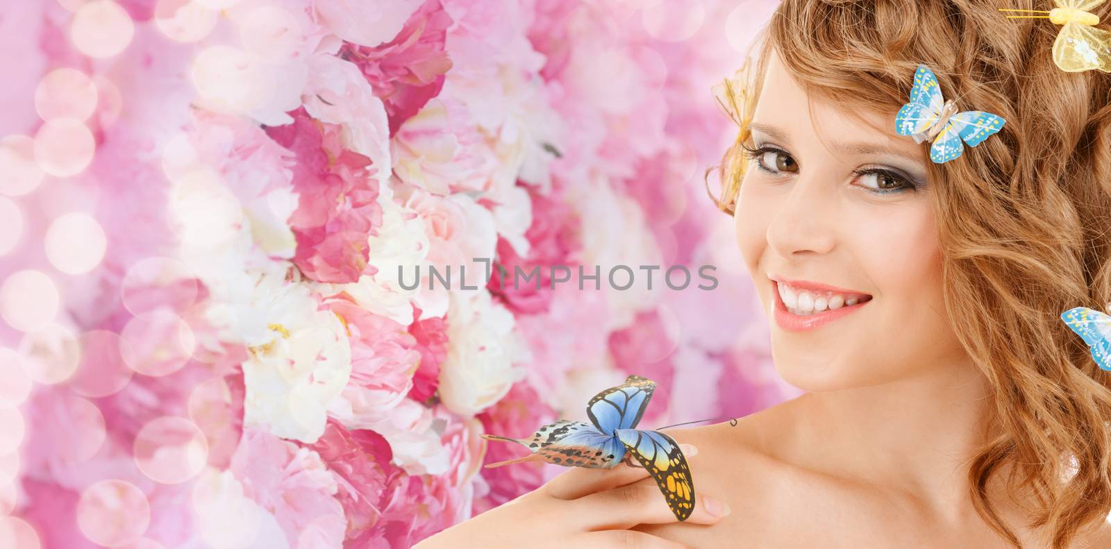 health and beauty concept - happy teenage girl with butterflies in hair and one sitting on her hand
