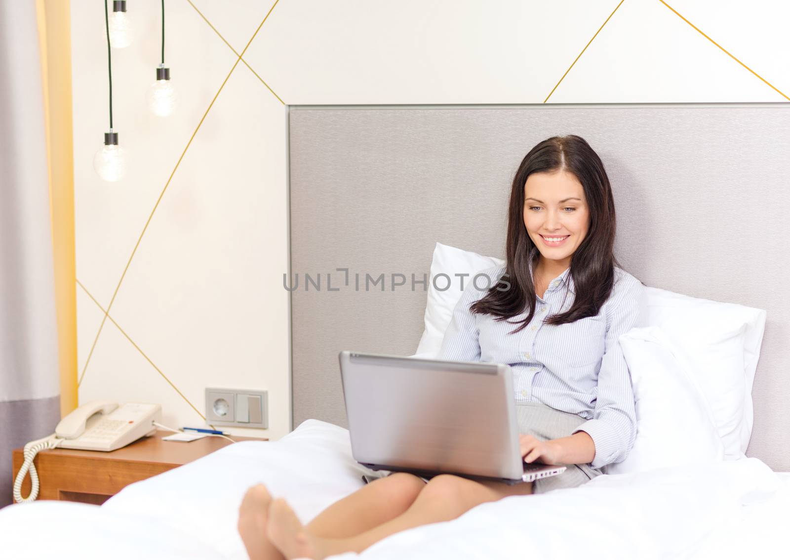happy businesswoman with laptop in hotel room by dolgachov