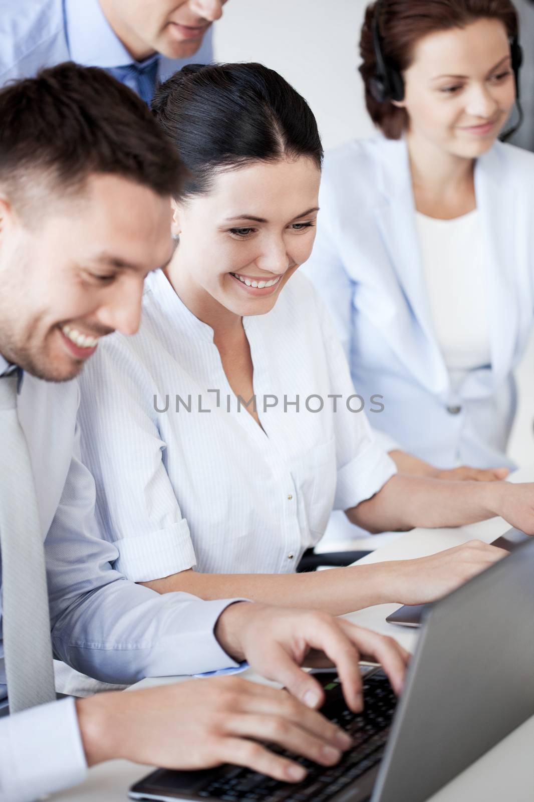 group of people working with laptops in office by dolgachov