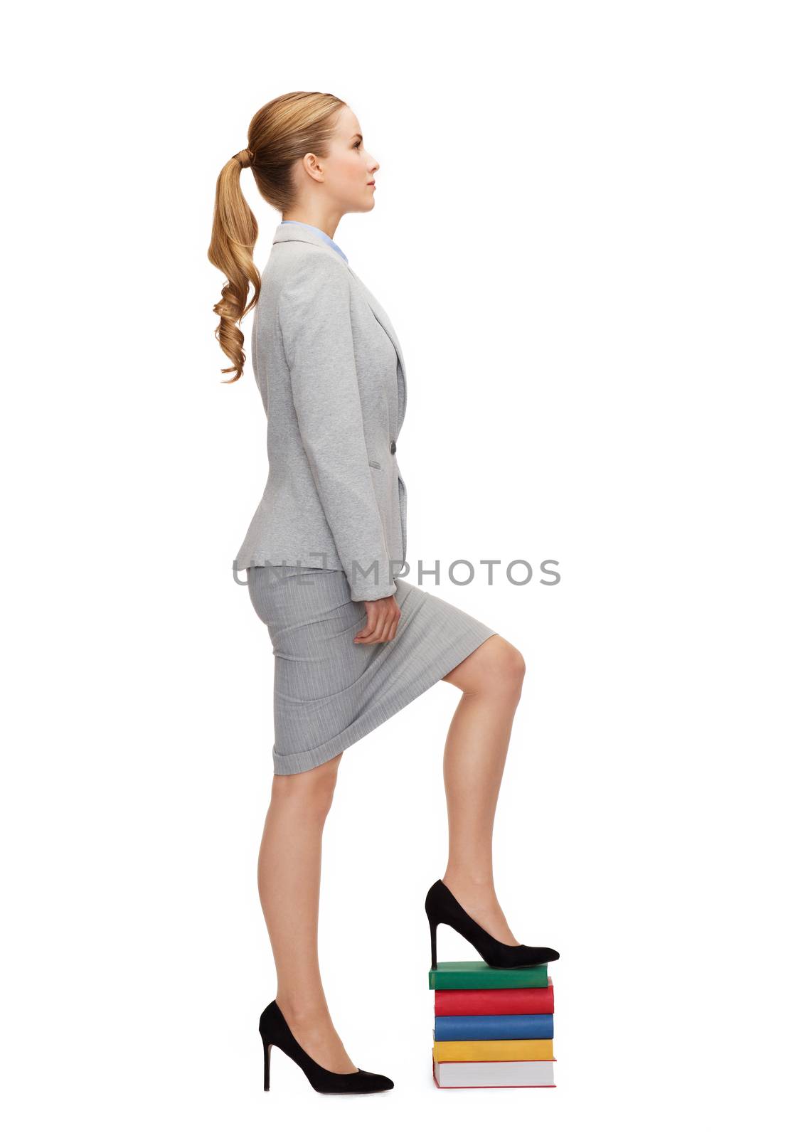 business and education concept - businesswoman stepping on pile of books