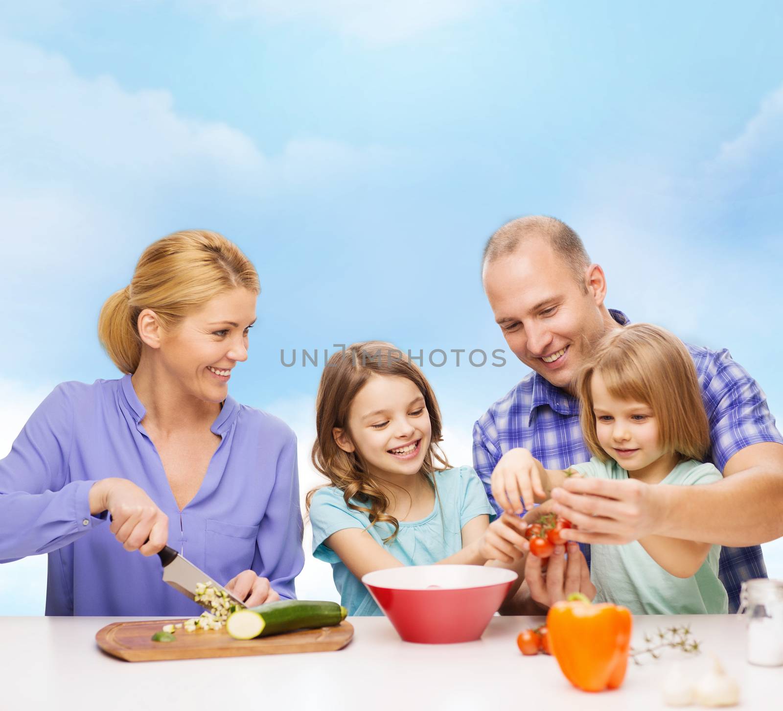 happy family with two kids making dinner at home by dolgachov