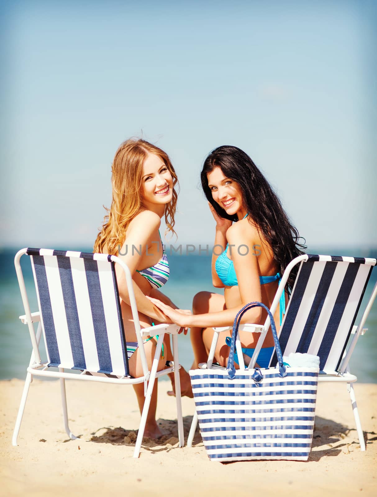 girls sunbathing on the beach chairs by dolgachov
