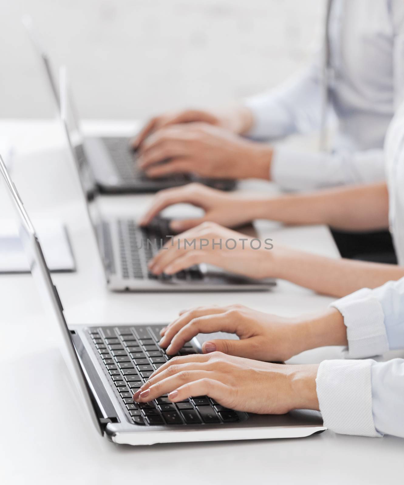 group of people working with laptops in office by dolgachov