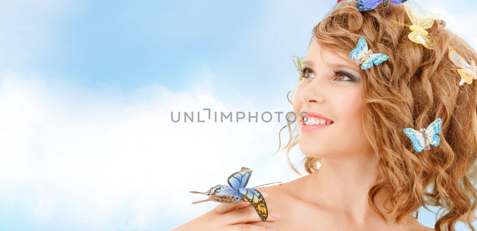 health and beauty concept - happy teenage girl with butterflies in hair and one sitting on her hand