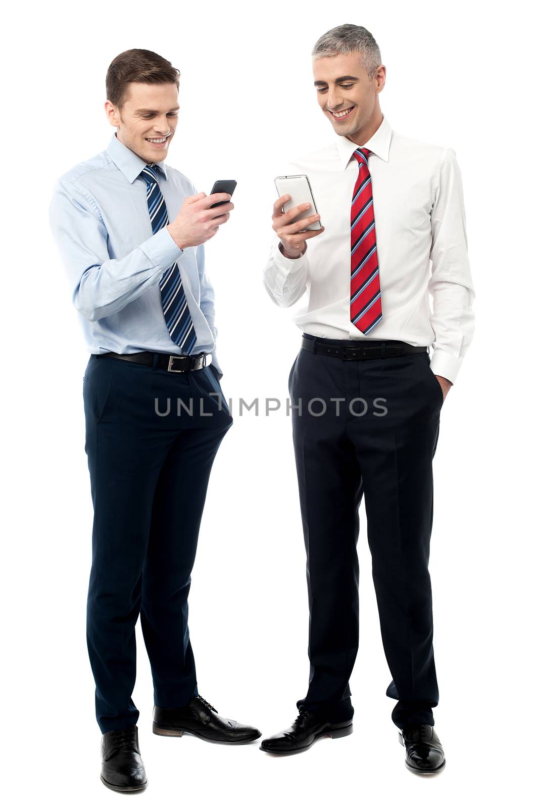 Young executives using mobile phone by stockyimages