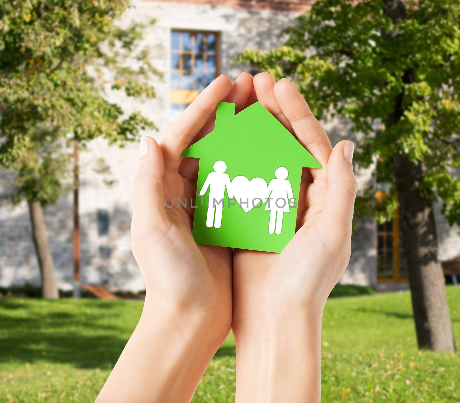 hands holding green house with family by dolgachov