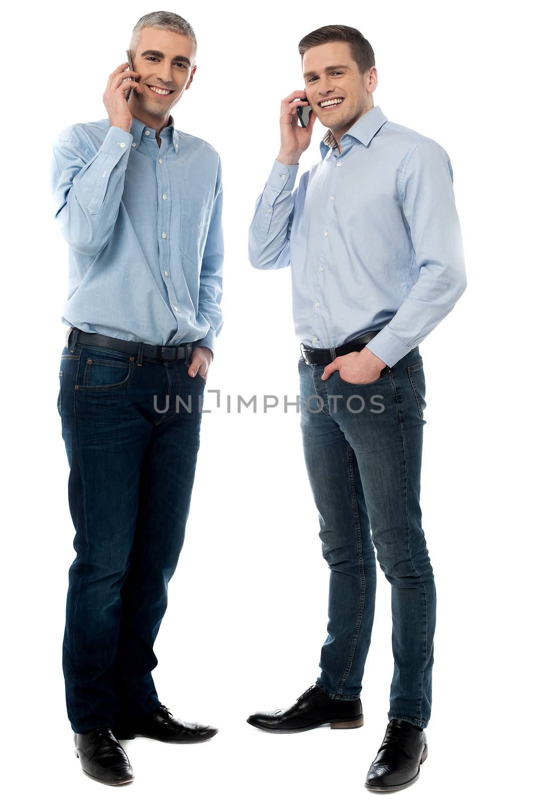 Young executives talking through mobile phone by stockyimages