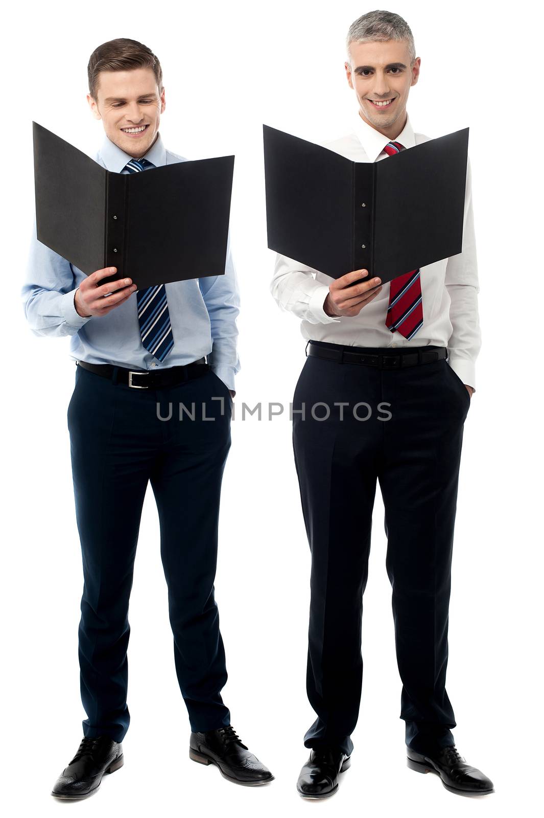 Smiling young executives with folder by stockyimages