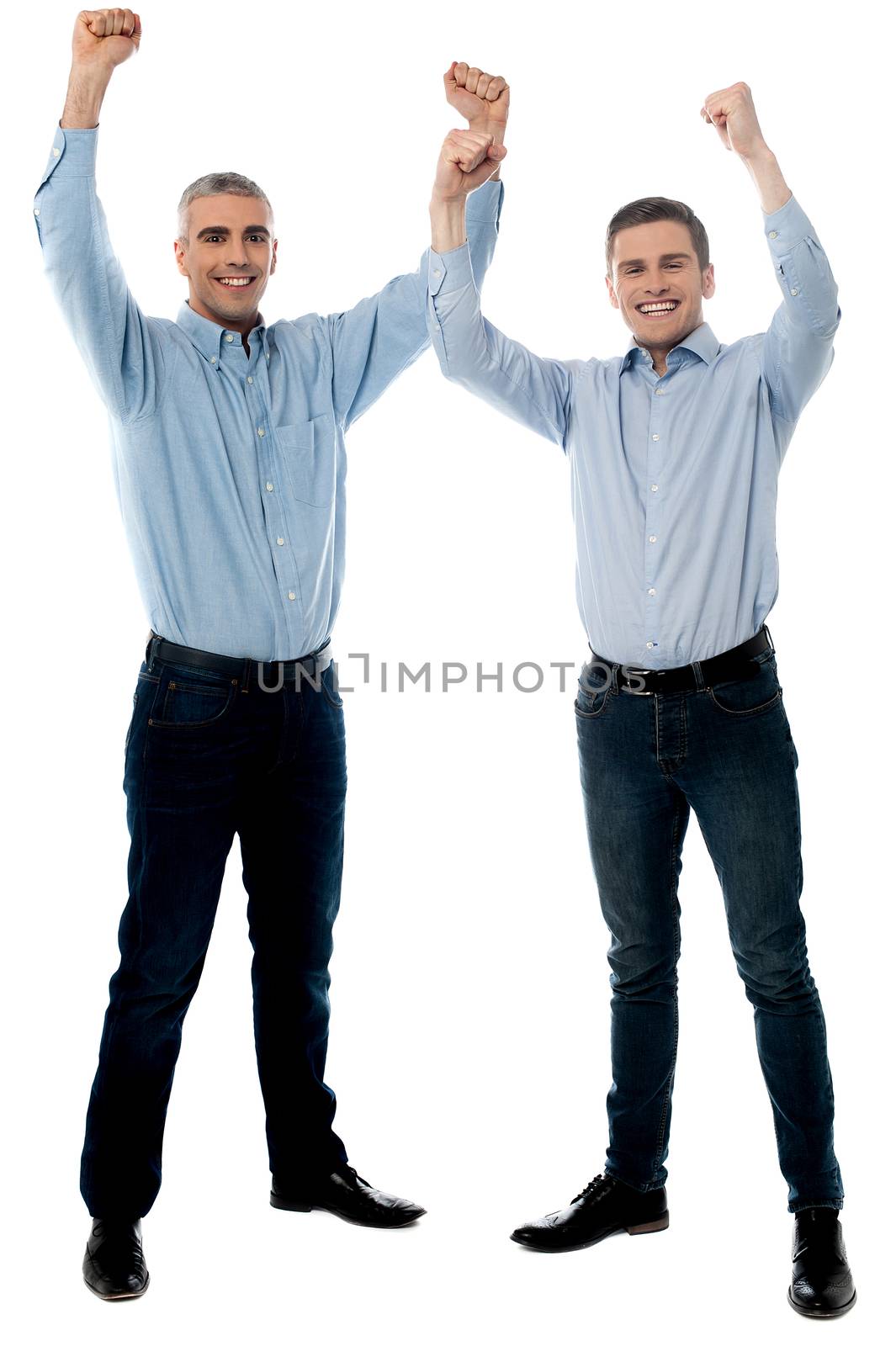 Successful handsome people celebrating with arms up