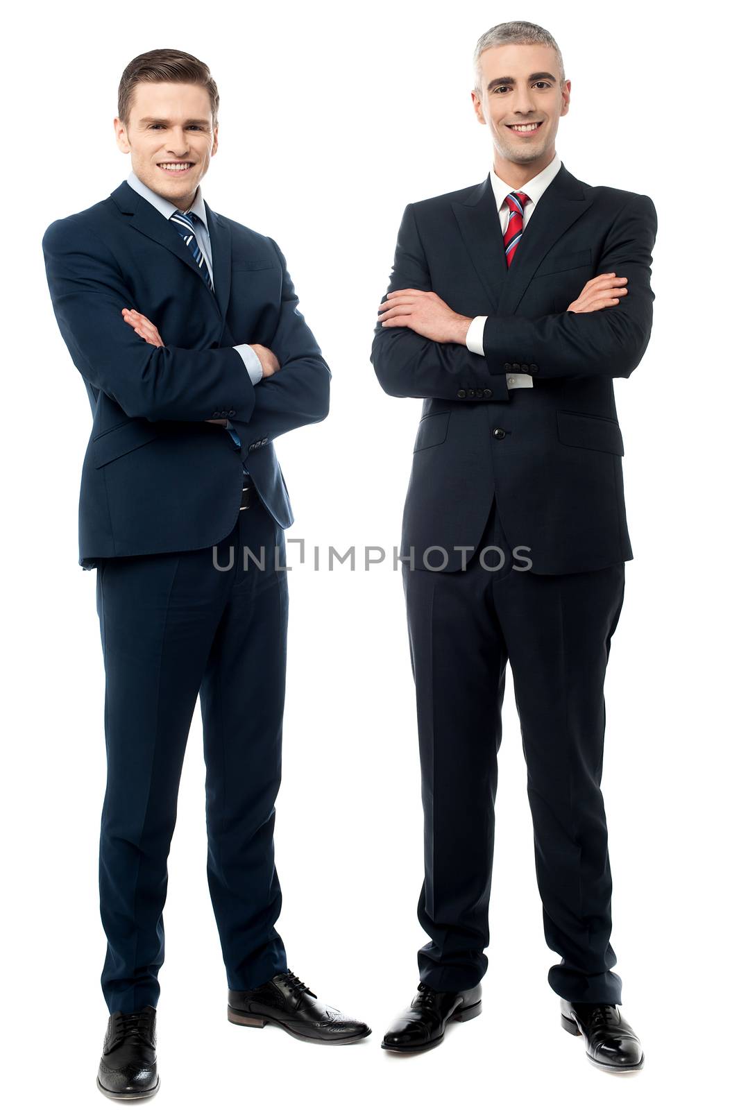 Confident businessmen in suits standing with arms folded