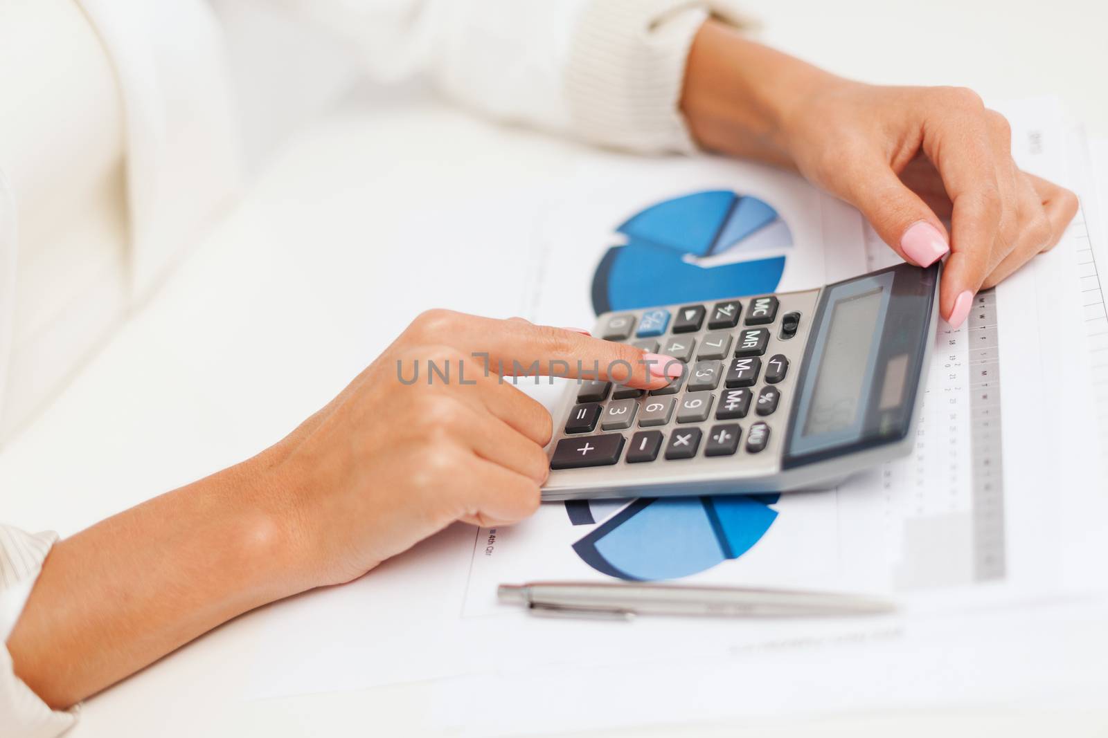 business and education concept - businesswoman with calculator, charts and graphs in office