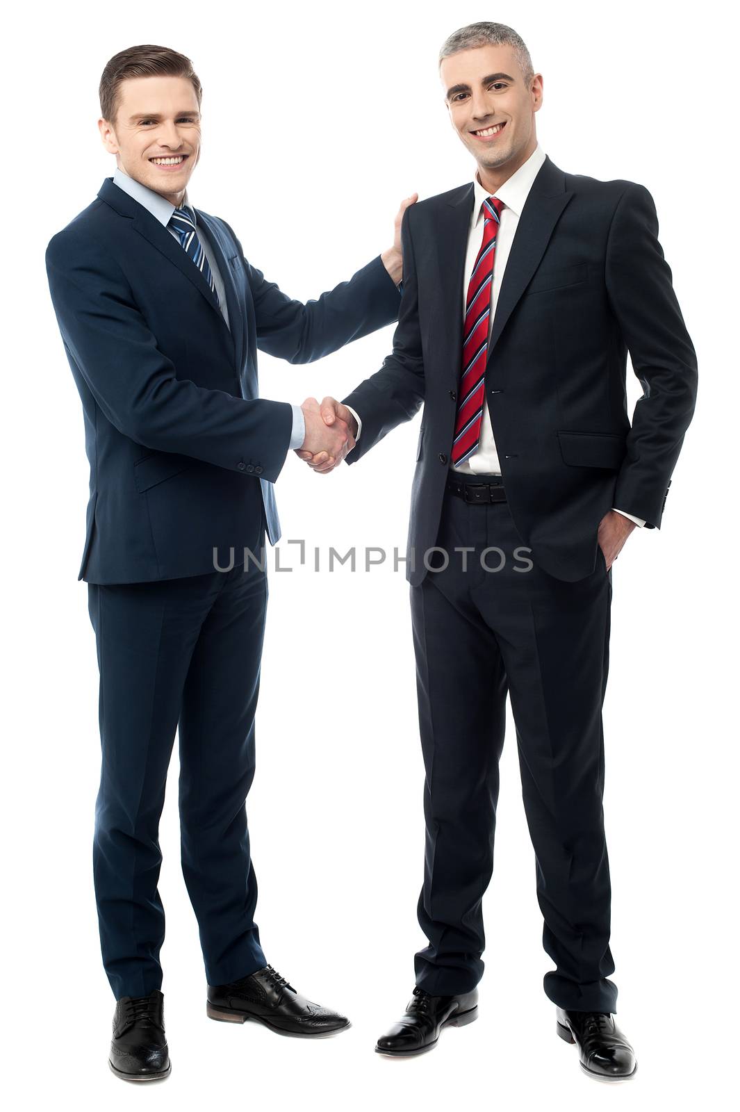 Successful businessmen shaking hands by stockyimages