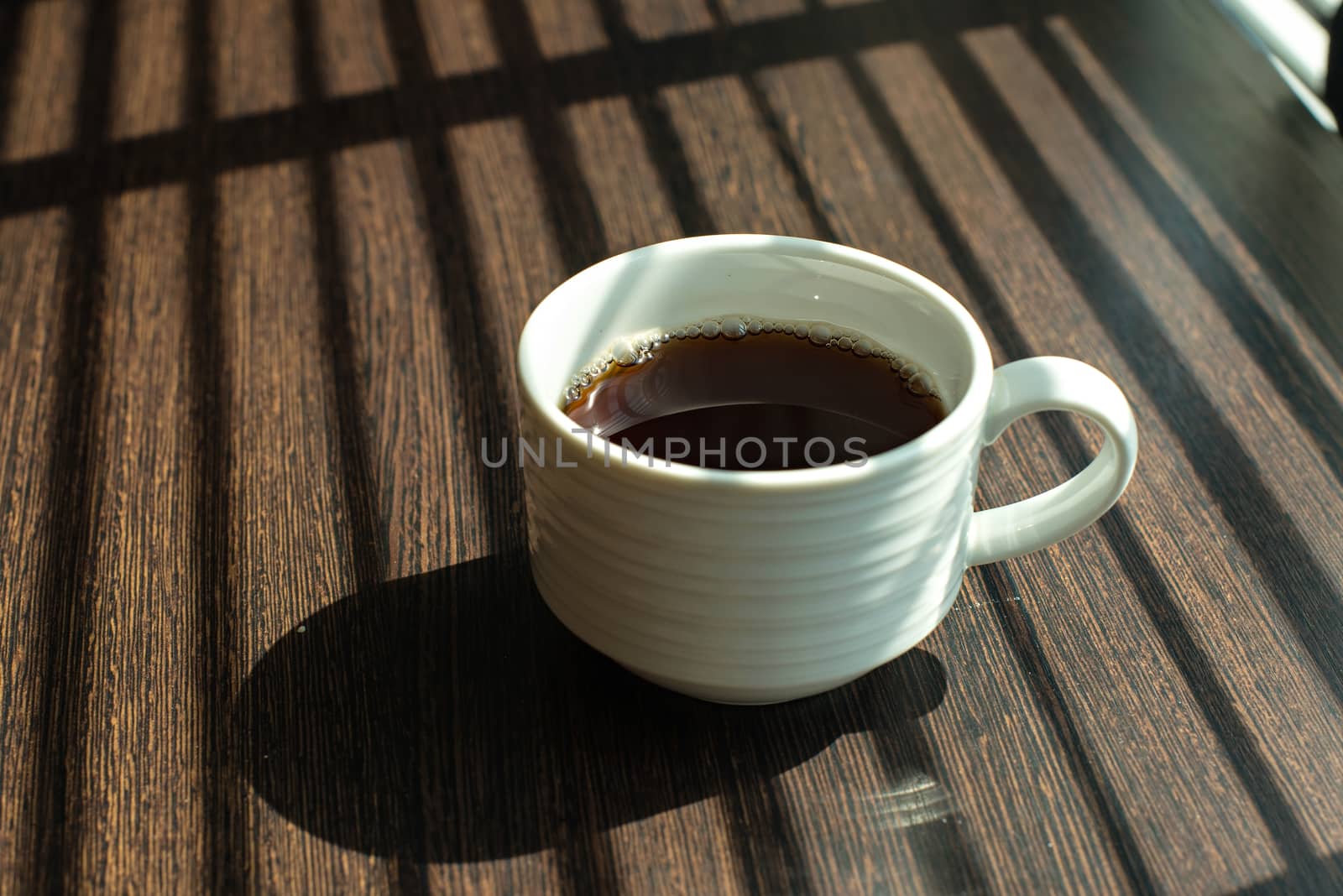 Hot Coffee cup on table near windows by Yuri2012