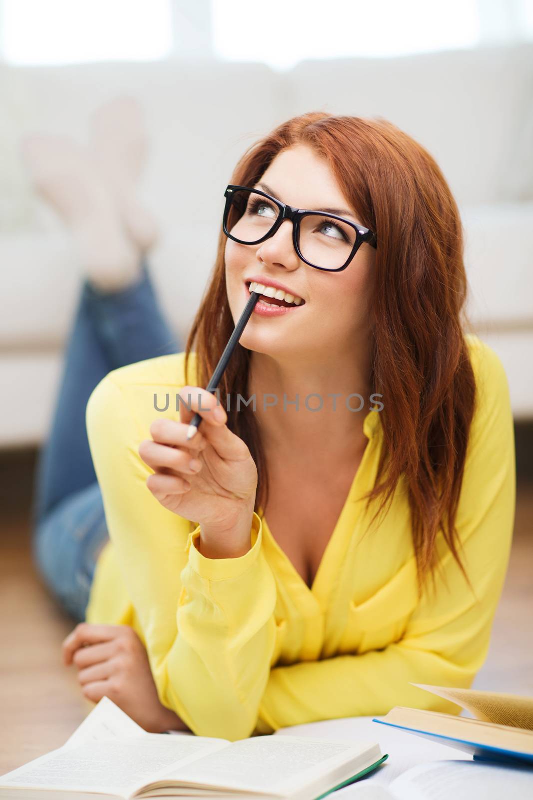 education and home concept - smiling student girl in eyeglasses reading books at home