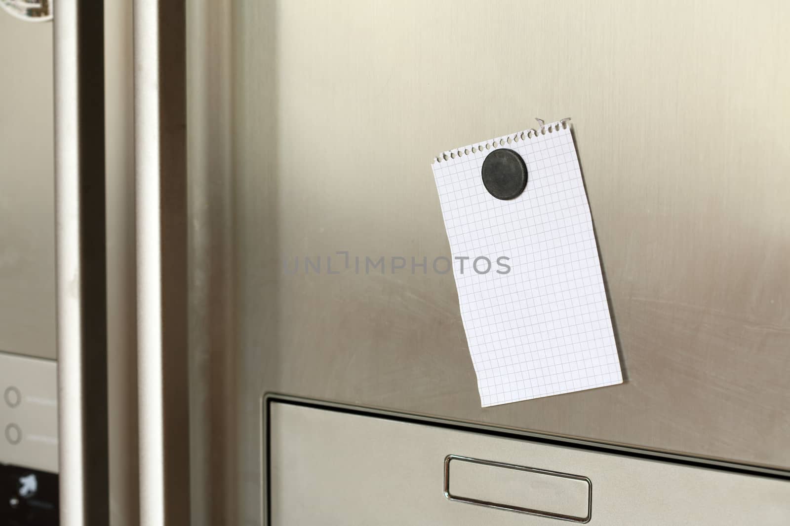 Blank paper and magnet on refrigerator door. 