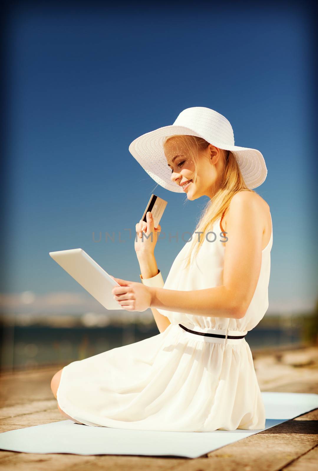 woman in hat doing online shopping outdoors by dolgachov