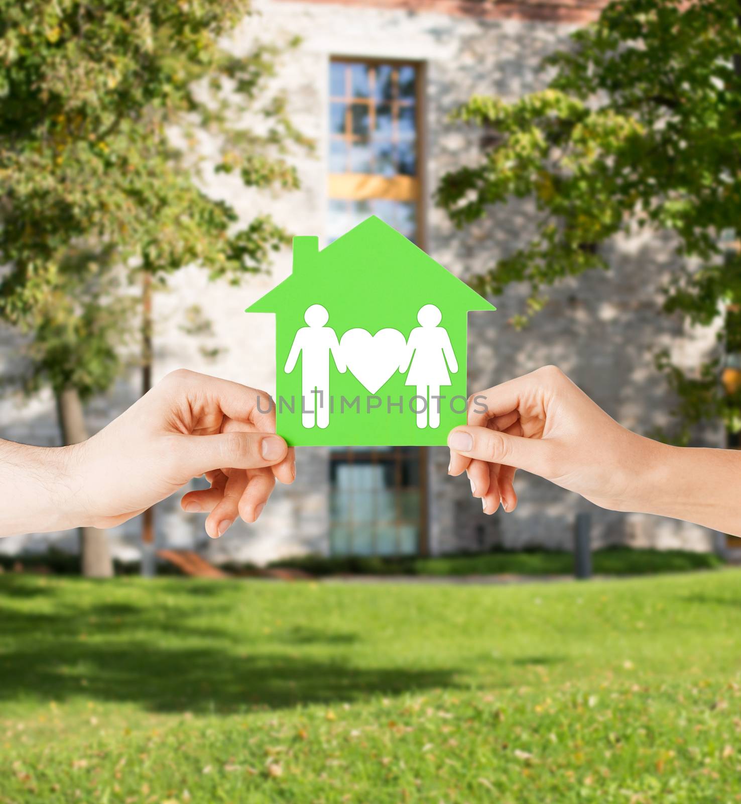 hands holding green house with family by dolgachov